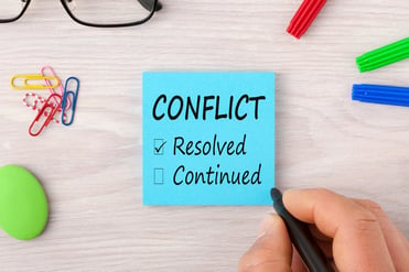 the word conflict on post-it note