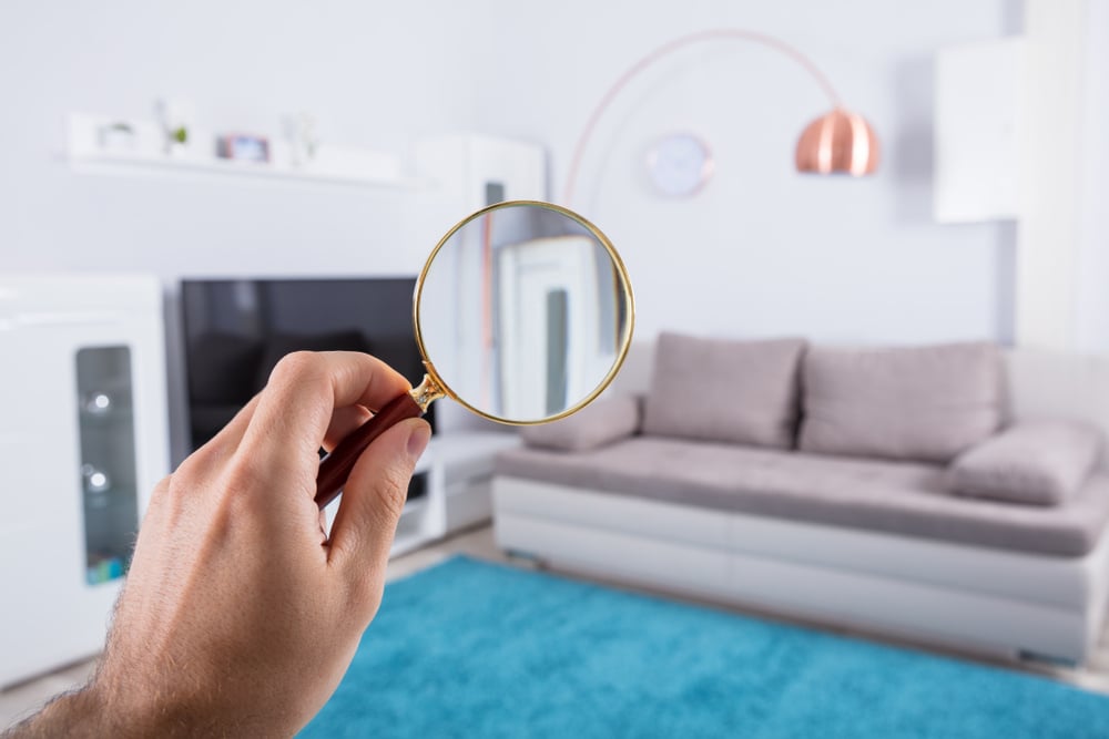 home property inspection concept with person holding magnifying glass at home