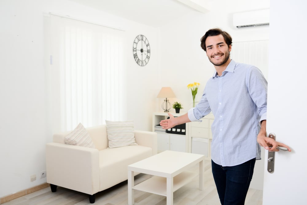 man welcoming people at front door