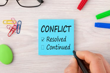 the word conflict on post-it note