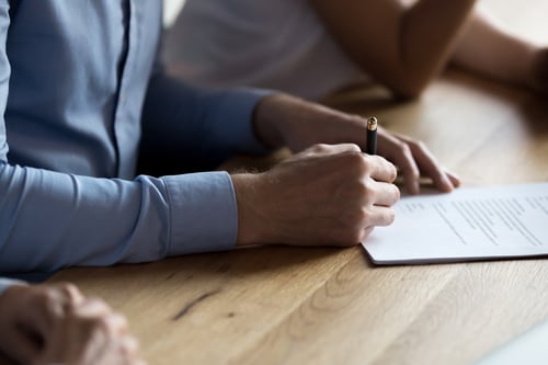 man signing rental lease