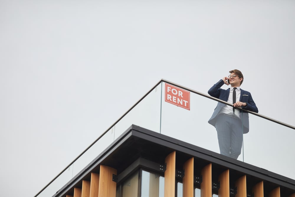real estate agent standing on roof of building
